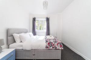 a white bedroom with a bed and a window at Hidden Gem, Bright 1BR flat wPatio in Lambeth in London