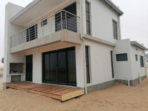 uma casa com grandes janelas e uma varanda em 074DB on Dune Lark em Walvis Bay