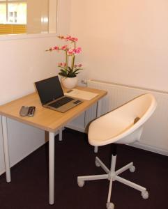 un bureau avec un bureau, un ordinateur portable et une chaise dans l'établissement Stadtwohnung in Calau (Spreewald), à Calau