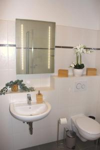 La salle de bains blanche est pourvue d'un lavabo et de toilettes. dans l'établissement Stadtwohnung in Calau (Spreewald), à Calau