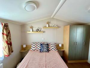 una camera da letto con un grande letto con cuscini sopra di Free Spirit - Landscove Holiday Park in Brixham a Brixham