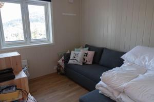 sala de estar con sofá y cama en Mountain Lodge by Homes & Villas, en Stryn