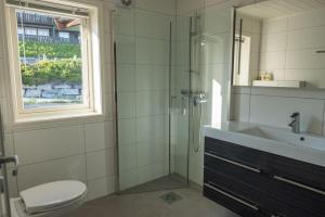 ein Bad mit einer Dusche, einem Waschbecken und einem WC in der Unterkunft Mountain Lodge by Homes & Villas in Stryn