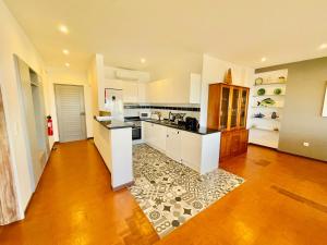 eine große Küche mit weißen Schränken und Holzböden in der Unterkunft Paraíso - Beachfront - Private Parking in Portimão