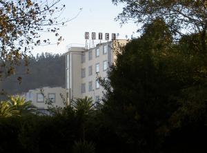 a white building with a tower on top of it at Hotel Sarga in Cabañas