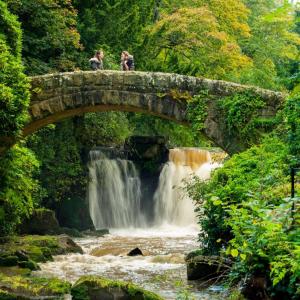 two people standing on a bridge over a waterfall at Central Jesmond 3BD Apt, Parking, Nr Newcastle in Jesmond