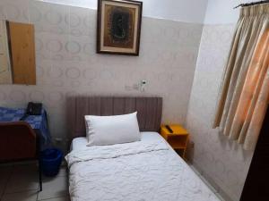 um pequeno quarto com uma cama e uma fotografia na parede em Résidences Touristhotel em Abidjan