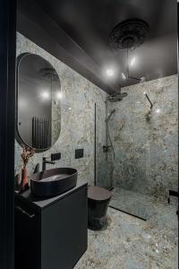 ein Badezimmer mit einem Waschbecken, einem Spiegel und einer Badewanne in der Unterkunft Hill Garden Residence & SPA in Palanga