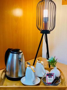 a table with a tea kettle and a lamp on it at Hotel La Ferté in Stuttgart