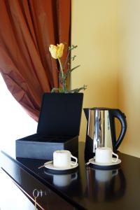 een tafel met twee kopjes en een waterkoker bij Bram Hotel in SantʼEufemia Lamezia