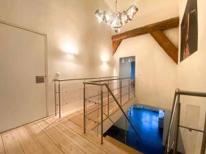 a staircase with a glass railing and a chandelier at Wadhuis met spectaculair uitzicht op zee! in Nes