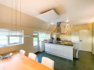 a kitchen with white cabinets and a wooden table at Wadhuis met spectaculair uitzicht op zee! in Nes