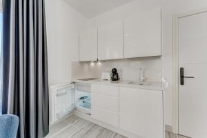 a kitchen with white cabinets and a sink at BAL Apartments Adults Only in Arona