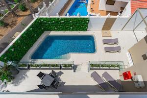 an overhead view of a swimming pool with chaise lounge chairs at BAL Apartments Adults Only in Arona