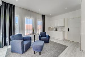 a living room with two blue chairs and a table at BAL Apartments Adults Only in Arona