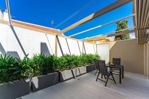 balcone con tavolo, sedie e piante di BAL Apartments Adults Only ad Arona