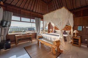 una camera da letto con un letto a baldacchino di Barong Bali Resort Ubud ad Ubud
