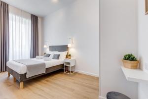 a white bedroom with a bed and a table at Colonna Luxury Apartment in Rome