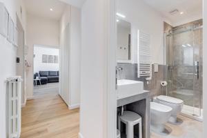 a white bathroom with a sink and a toilet at Colonna Luxury Apartment in Rome +30 photos