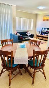 カルグーリーにあるKalgoorlie Accommodationのリビングルーム(木製テーブル、椅子付)