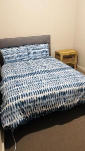 a bed with a blue and white comforter in a bedroom at Kalgoorlie Accommodation in Kalgoorlie