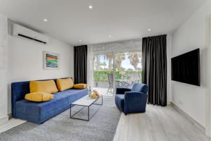 a living room with a blue couch and two chairs at BAL Apartments Adults Only in Arona
