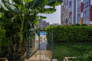 a fence with a tree next to some buildings at Residence w Shared Pool 3 min to Mall of Antalya in Antalya