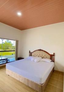 um quarto com uma cama grande e uma janela grande em Amadeo Guest House em Ratodena