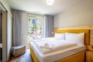 a bedroom with a large bed with a window at SWISSPEAK Resorts by Pierre & Vacances Premium Meiringen in Meiringen