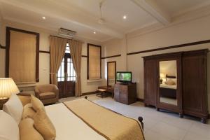 a bedroom with a bed and a television in it at Hotel Suisse in Kandy