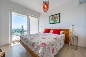 a bedroom with a bed with red pillows and a window at Villa Rozeta in Marčana