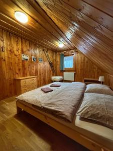 テルホヴァーにあるChata pod Kyčerouの木造キャビン内のベッドルーム1室(大型ベッド1台付)