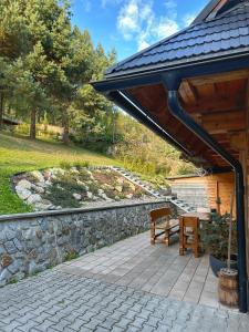 a patio with a bench and a stone wall at Chata pod Kyčerou in Terchová