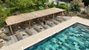 - une vue sur la piscine avec des chaises et une maison dans l'établissement Résidence U Frusteru, à Propriano