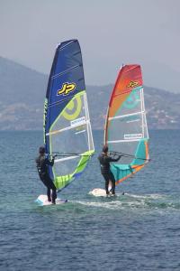 dos personas de pie en tablas de surf con windsurf en Les Pins YourHostHelper, en Cagnes-sur-Mer