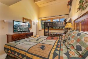 Dormitorio con cama, TV y cuna en Trails End Penthouse - Ski In - Out - Stroll To Main Street en Breckenridge