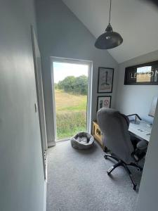 伊普斯威奇的住宿－Hall Farm Cottage, Barham，一个带椅子和书桌的办公室和一个窗口