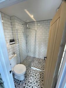 a bathroom with a toilet and a tiled floor at Hall Farm Cottage, Barham in Ipswich