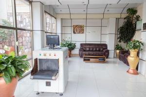 a waiting room with a tv and a couch at Olympic Hotel in Kigali