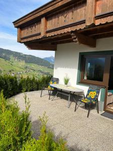 un patio con tavolo e sedie di fronte a un edificio di Ferienwohnung Prantner a Sellrain