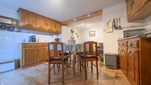 a kitchen with wooden cabinets and a table and chairs at The Dolls House in Aldeia de João Pires