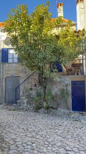 un árbol en el lateral de un edificio con una escalera en The Dolls House en Aldeia de João Pires