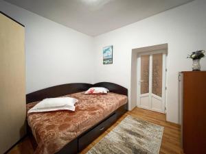 1 dormitorio con 1 cama con 2 almohadas en Căsuța Măriuca, en Greci