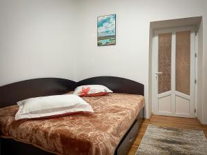 uma cama com duas almofadas num quarto em Căsuța Măriuca em Greci