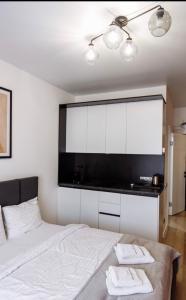 ein Schlafzimmer mit einem weißen Bett mit zwei Handtüchern darauf in der Unterkunft Arena Apart - Hotel in Poljana