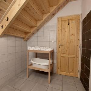 ein Badezimmer mit einem WC und einer Holztür in der Unterkunft Apartmány U Tří Sluncí in Hroubovice