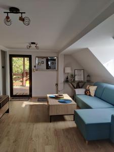 a living room with a blue couch and a table at Pod Wieżą u Kory in Siedlęcin