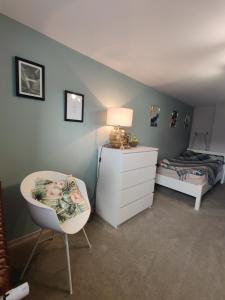 a bedroom with a bed and a white dresser and a chair at Pod Wieżą u Kory in Siedlęcin