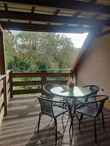 a patio with a table and chairs on a deck at Pod Wieżą u Kory in Siedlęcin