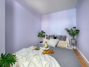 Un dormitorio con una cama y una mesa con fruta encima. en Apartament przy Rynku Długa 23, en Cracovia